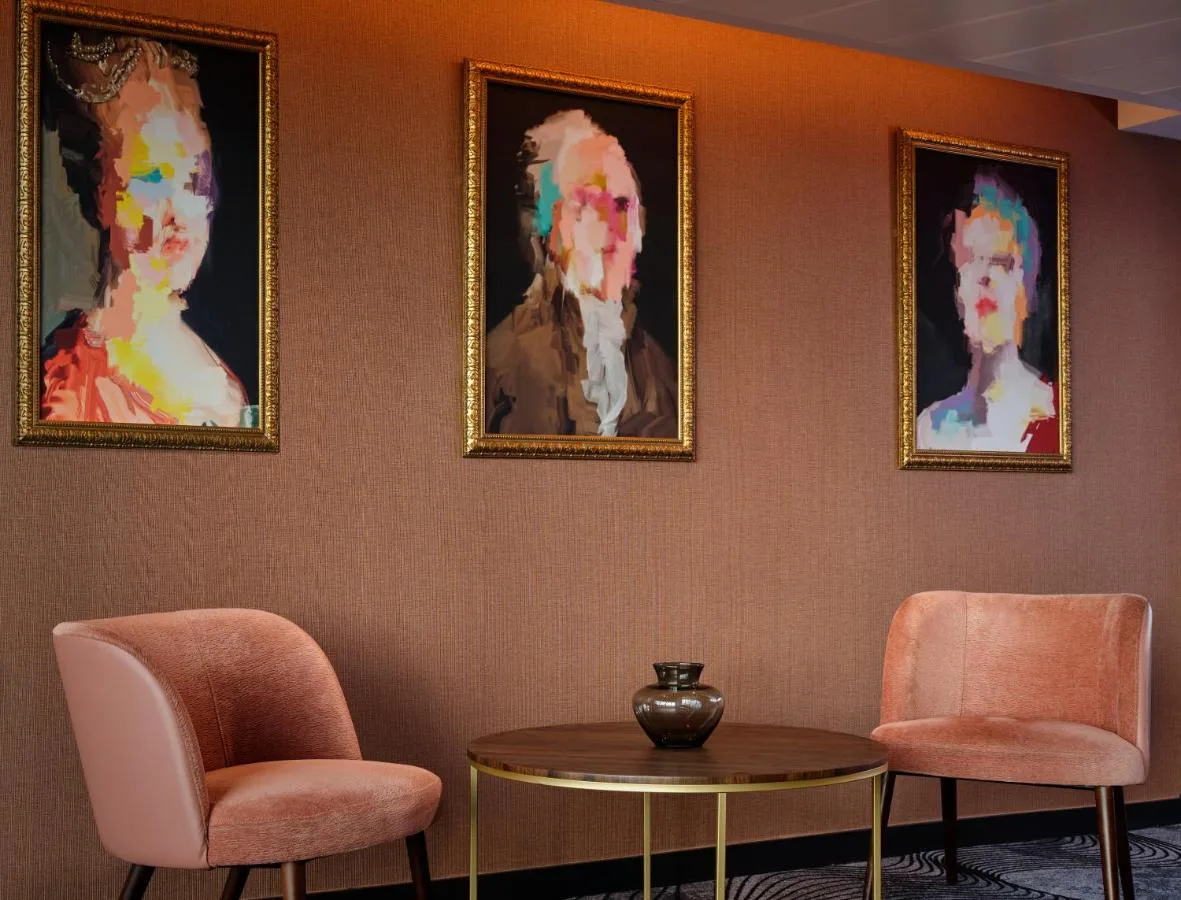 Room with armchairs, table and artwork